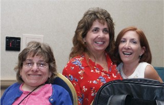 Three women with dwarfism smiling.