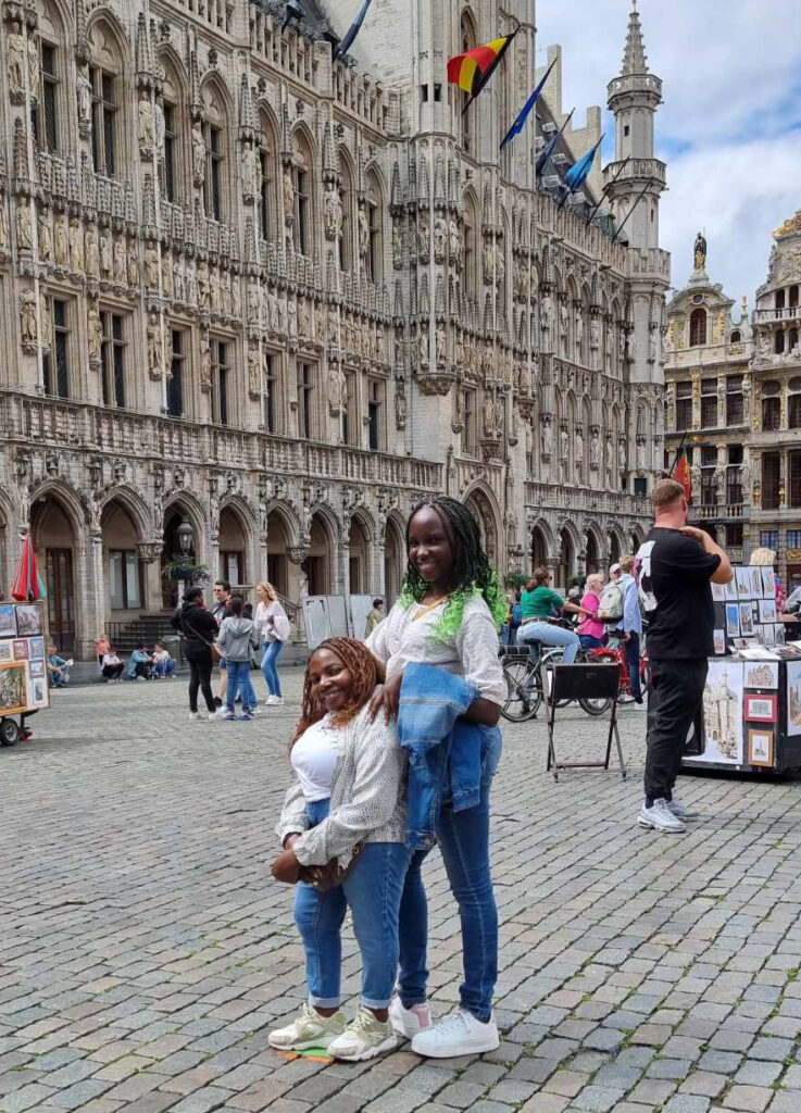 Beautiful woman with SMDK in a European city. She is wearing a white shirt, blue jeans and had beautiful braids.